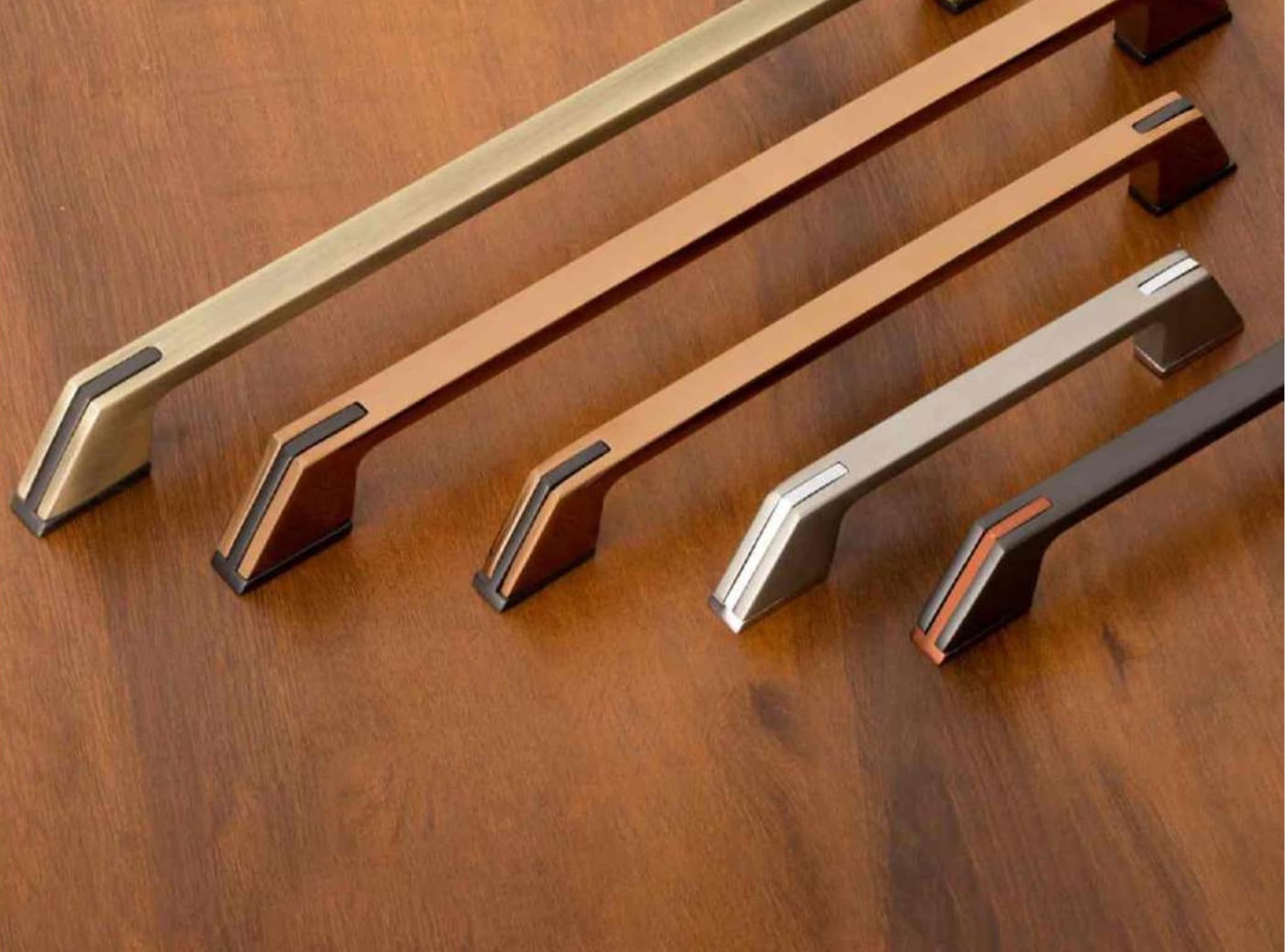 Assortment of premium cabinet handles on a wood surface